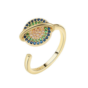 Gold spinner ring with saturn charm on a white background