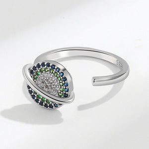 Silver spinner ring with saturn charm on a white background