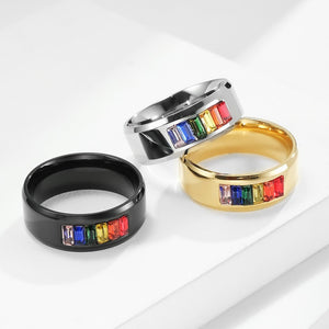 Four rings in black, silver, gold, and rainbow colors on a white background