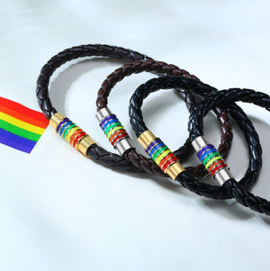 Two braided leather bracelets with rainbow beaded ends on a white background