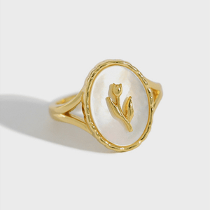 Gold ring with a tulip design on a white background