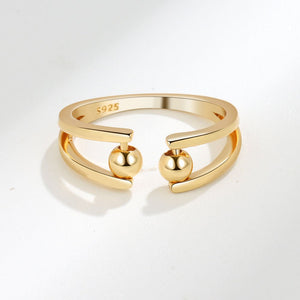 Gold ring with spherical elements on a white background