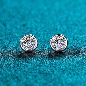 Pair of diamond stud earrings on a textured blue background