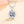 Silver necklace with a diamond pendant on a beige background