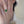 Model wearing a gold ring with green and white stones