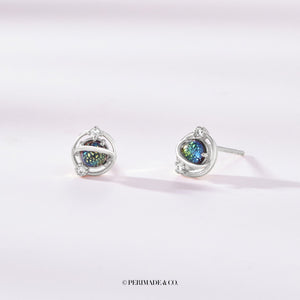 A pair of stud earrings featuring a space-like pattern with gold plating and colorful glass inserts.