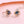 Pair of rose gold earrings with blue gemstones on a pink background