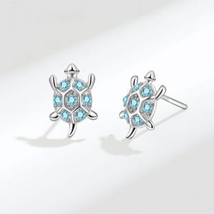 A pair of small blue sea turtle stud earrings made of sterling silver with hypoallergenic finish.