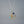Gold pendant with sun, moon, and star design on a gray background