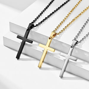 Three cross necklaces in black, gold, and silver on a white surface