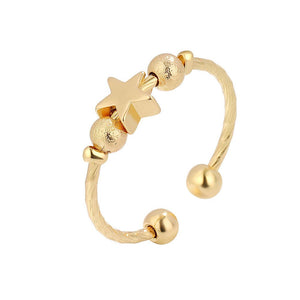 Gold spinner ring with star and round beads on a white background