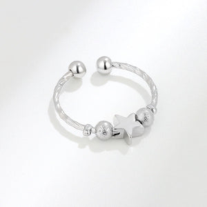 Silver spinner ring with star and round beads on a white background