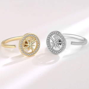 Gold and silver spinner rings with star designs on a light background