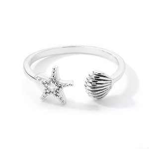 Silver ring with starfish and shell designs on a white background.