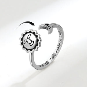 Silver open ring with engraved text on a light gray background