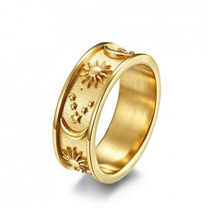 Gold celestial engraved ring with sun, moon, and stars design on a wide band