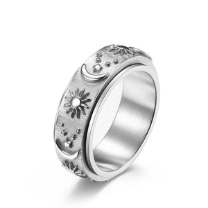 Silver celestial spinner ring with engraved sun, moon, and star details on a textured band