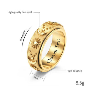 Gold celestial spinner ring with engraved sun, moon, and star details on a textured band