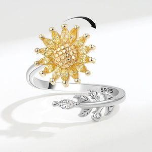 Gold sunflower-shaped ring and silver leaf-shaped ring on a white background