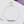 Sterling silver bracelet with gold plating and multicolored gemstone accents, displayed on an open book.