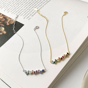 Two sterling silver bracelets with gold plating and multicolored gemstone accents, displayed on an open book.