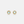 Pair of gold sun-shaped earrings with light blue gemstones on a light gray background
