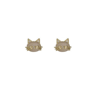 A person's hand holding a pair of silver and gold-plated opal cat stud earrings.
