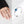 Woman wearing a spinner ring with blue and black evil eye beads on a white background