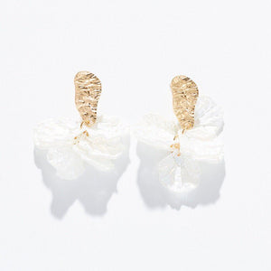 Pair of earrings with gold and white design on a light gray background