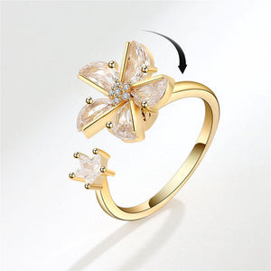 Gold ring with floral design on a light gray background